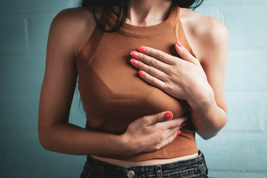 Woman holding her chest because of heartburn, a common GERD symptom